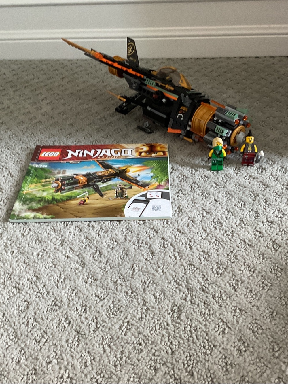 Lego black and orange jet fighter with green accents and minifigures